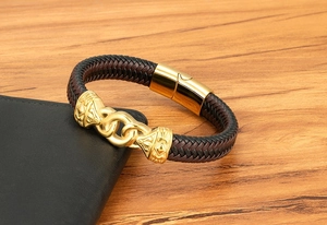 Detail of woven leather bracelet with gold magnetic clasp on a dark leather wallet