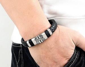 Gros plan d'un bracelet en cuir tressé pour hommes avec fermoir dollar en acier inoxydable