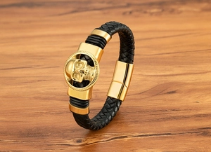 Dettaglio di un bracciale in pelle da uomo con teschio dorato e chiusura magnetica