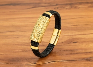 Nahaufnahme von goldenem Metall-Charm auf schwarzem Lederarmband mit Magnetverschluss