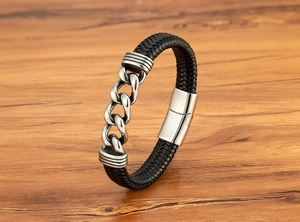 Nahaufnahme des geflochtenen Lederarmbands für Herren mit Kette auf Holzuntergrund