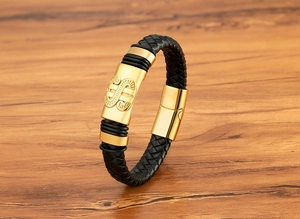 Détail d'un bracelet en cuir tressé noir pour homme avec fermoir magnétique doré et relief