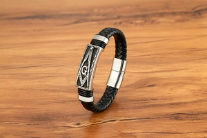 Gros plan détaillé du bracelet en cuir tressé noir avec fermoir maçonnique G argenté