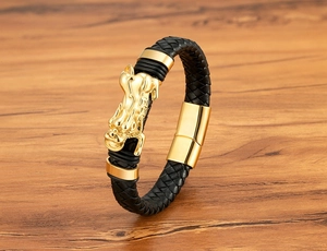 Nahaufnahme des goldenen Drachenanhängers am schwarzen Lederarmband mit Magnetverschluss
