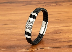 Gros plan d'un bracelet en cuir tressé pour homme avec élément en acier gravé et fermoir magnétique