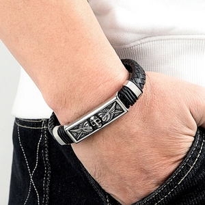 Men's punk leather bracelet with silver skull wing metal plate on model wrist