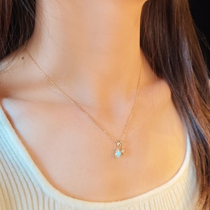 Exquisite gold necklace with moonstone teardrop pendant and tiny star on female model