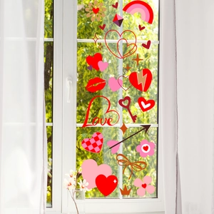Detail van Valentijn raamstickers met rode harten en bloemen op een glazen ruit