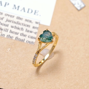 Detailopname van hartvormige groene agaat ring met diamanten bladaccenten op band