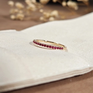 Close-up of S925 sterling silver ring with red corundum stones on textured fabric
