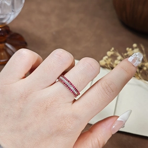 Detail of stacked S925 silver rings with red corundum and pavé set white zircon stones