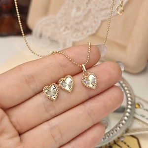Vue macro détaillée du parure coeur en argent S925 avec texture laser soleil dorée