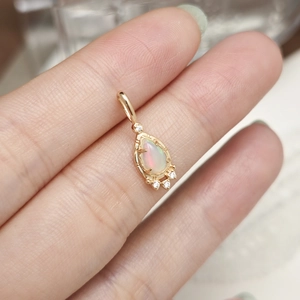 Makroaufnahme eines birnenförmigen Opal-Anhängers mit goldener Fassung zur Größenschau