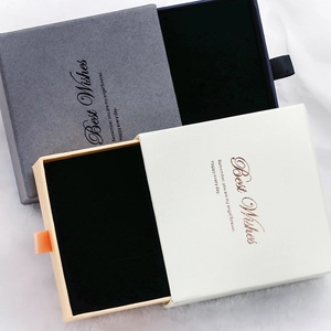 Détail de boîtes cadeaux à bijoux en gris et crème avec doublure en velours noir doux