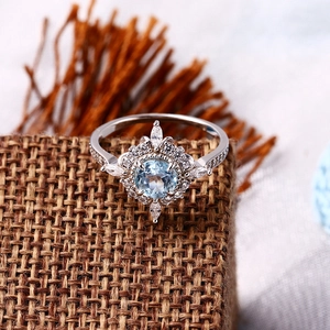 Macro shot of a 925 silver ring with a sky blue stone surrounded by white zircons