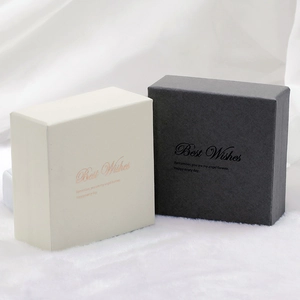 Boîtes à bijoux élégantes ivoire et noires avec lettrage doré sur fond de tissu blanc doux