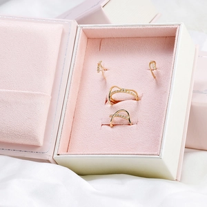 Détail d'une parure en or et zircon avec bagues et boucles en boîte de velours rose