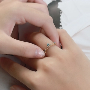 Close-up van een 925 zilveren vergulde ring met blauwe topaas aan een vinger