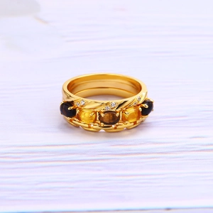 Detalle de anillos de plata S925 bañados en oro con gemas de color ámbar y microdiamantes