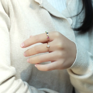 Detailed view of gold S925 silver rings with colorful stones and white opal on finger