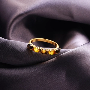Primer plano de anillo de plata S925 bañada en oro con cinco citrinos sobre seda fina