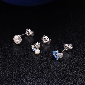 Makroansicht von S925 Silber-Muschelohrringen mit Perlen und hellblauen Saphiren