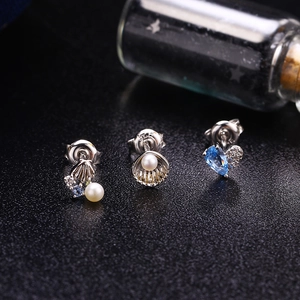 S925 Silber Meeres-Ohrringe Set mit Muscheln und Perlen auf dunklem Hintergrund