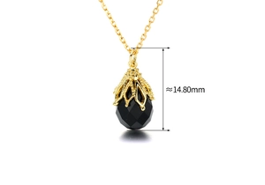 Macro-opname van druppelvormige zwarte onyx hanger met gouden opengewerkte kroon