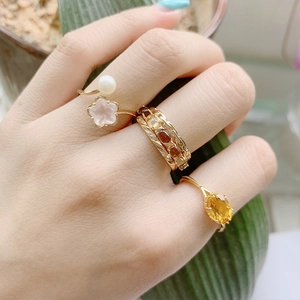 Detalle de anillo de plata S925 bañada en oro con flor de cerezo cristal y perla
