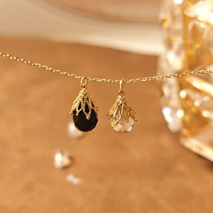 Macro-opname van facetgeslepen onyx en kristallen hangers met gouden filigraan kapjes