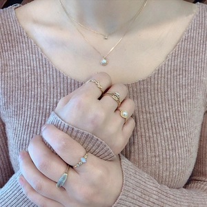 Detail eines Süßwasserperlen-Schmucksets mit goldenen Halsketten und Ringen am Modell