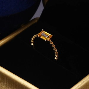Makroaufnahme eines rechteckigen gelben Edelsteinrings mit goldener Vintage-Band
