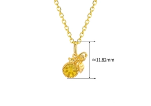 Detail shot of a golden bee pendant with yellow amber gemstone and 11.82mm size marker