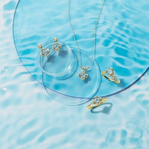 Exquisite clover jewelry set with blue gemstones and gold finish on acrylic plates