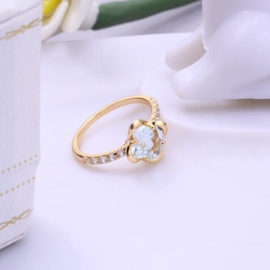 Elegant 18K gold clover ring with heart-cut crystals and pavé zircon accents on the band
