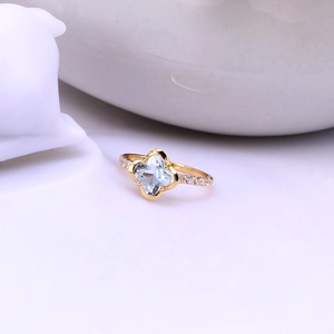 Detail of 925 silver gold clover ring with blue topaz and pavé set cubic zirconia