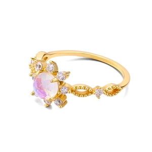 Nahaufnahme eines goldenen Blumenrings mit Mondstein-Zentrum und weißen Zirkonia-Steinen
