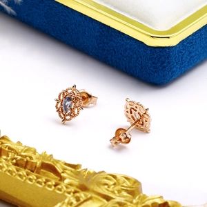Pendientes de flores en oro rosa con topacio azul marquesa sobre caja de terciopelo