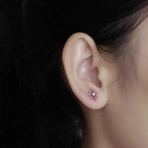 Primer plano de los pendientes de filigrana en oro rosa con piedra marquesa azul