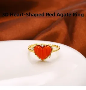 Detailansicht eines 3D-Herzrings aus rotem Achat mit Goldband und funkelnden Akzenten