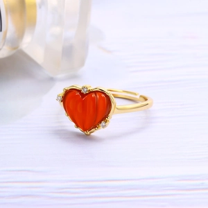 Detail eines goldenen offenen Rings mit rotem Herz-Achat und kleinen Zirkon-Akzenten