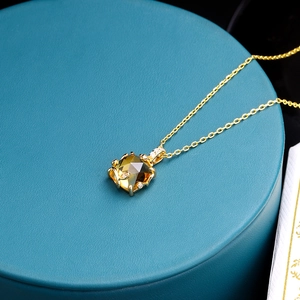 Dettaglio macro di un ciondolo a boccetta di profumo in argento 925 con cristallo giallo