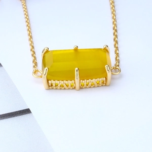 Macro view of gold bracelet with rectangular yellow chalcedony in a six-prong setting