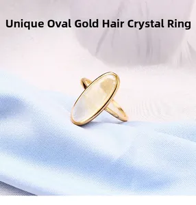 Vue détaillée d'une bague en quartz rutilé ovale avec des inclusions dorées sur tissu