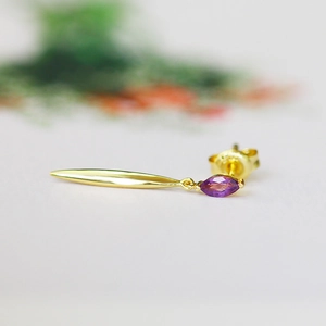 Macro shot of a S925 silver gold-plated earring with marquise-cut purple amethyst stone