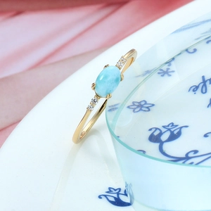 Close-up of gold S925 silver ring featuring oval Larimar stone and zircon accents
