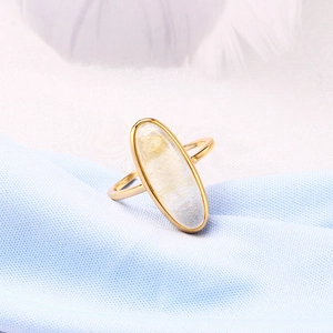 Détail macro d'une bague en argent S925 doré avec quartz rutilé ovale