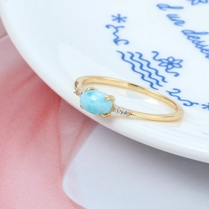 Exquisite Larimar ring in silver gold-plated band with zircon accents on a white dish