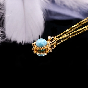 Macro-opname van Larimar zonnestralen hanger met blauwe steen en goudkleurige ketting