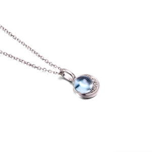 Close-up van 925 zilveren maan hanger met blauwe topaas en kleine witte stenen